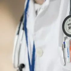 Lekarz orzecznik ZUS w białym kitlu ze stetoskopem i przyborami w kieszeni. Forum: o co pyta lekarz orzecznik ZUS?