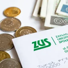 Złote monety i banknoty na białym tle, obok dokumentu ZUS.