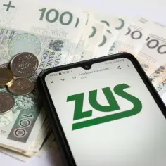 Polskie banknoty i monety na tle ekranu telefonu z logo ZUS.