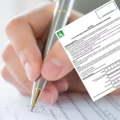 Dłoń z długopisem wypełnia wniosek ZUS o rentę rodzinną.