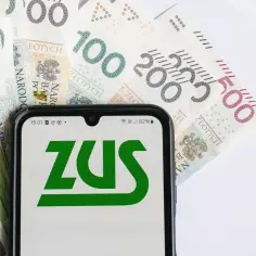 ZUS świadczenie wspierające na ekranie telefonu, otoczone polskimi banknotami. Finansowe wsparcie od państwa.