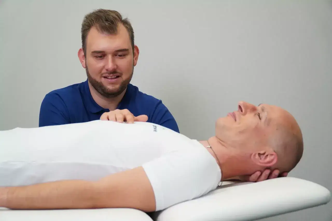 Terapeuta wspiera pacjenta w leczeniu nerwicy, dotykając jego klatki piersiowej.